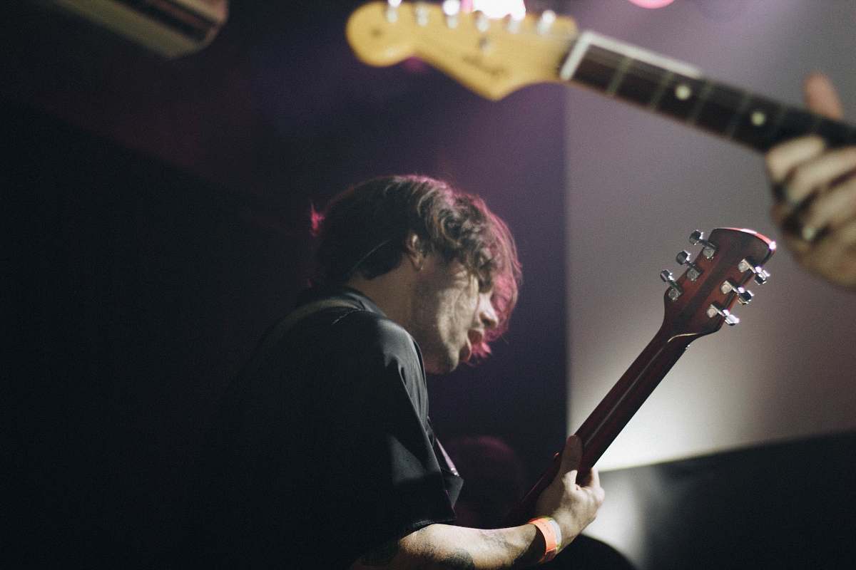 guitar man wearing black shirt standing while playing guitar electric guitar